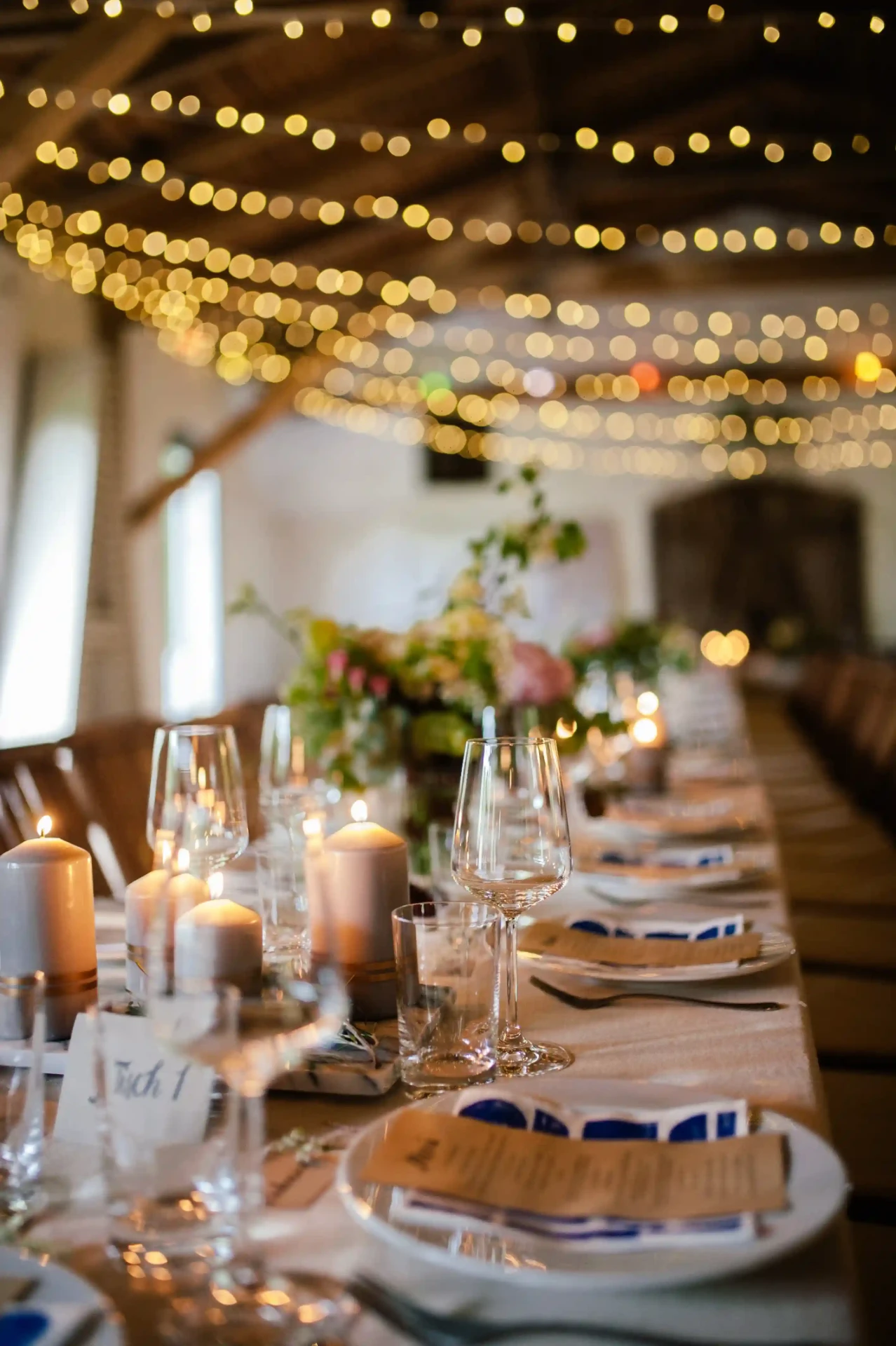 Long set table in a barn with warm lighting