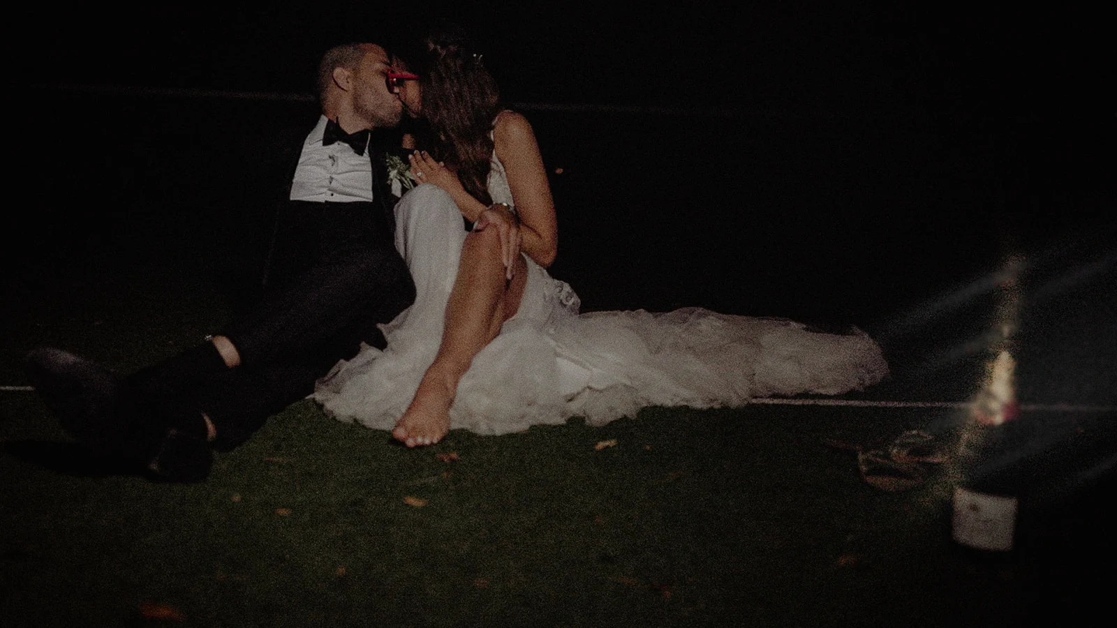 Bride and groom sharing an intimate moment on the lawn at night