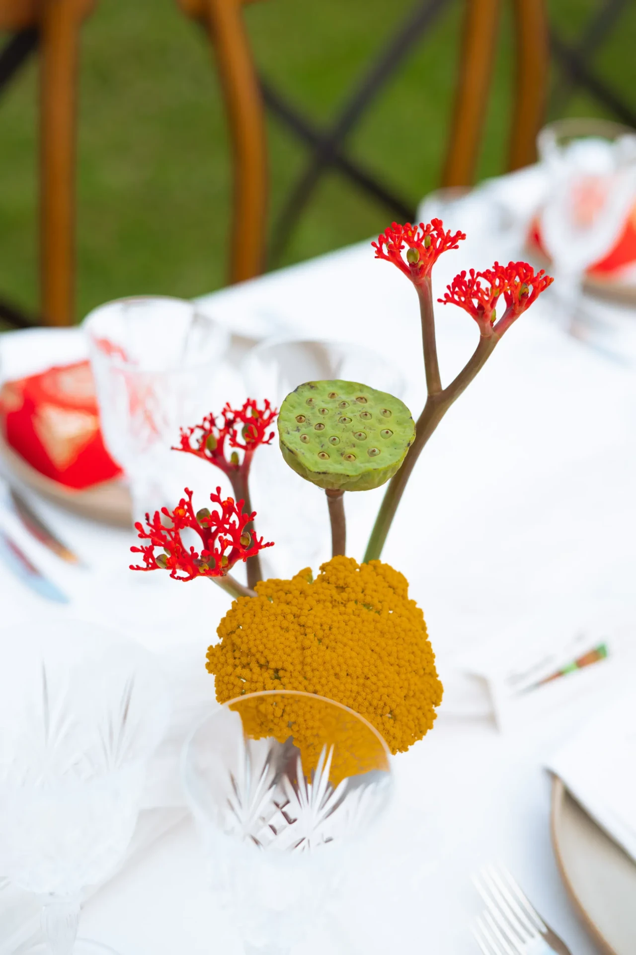 Floral table detail with red and yellow flowers on a white tablecloth