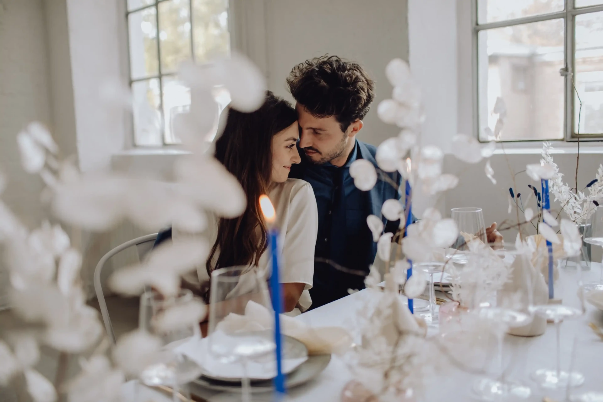 Wedding couple seated at a white wedding table with blue details