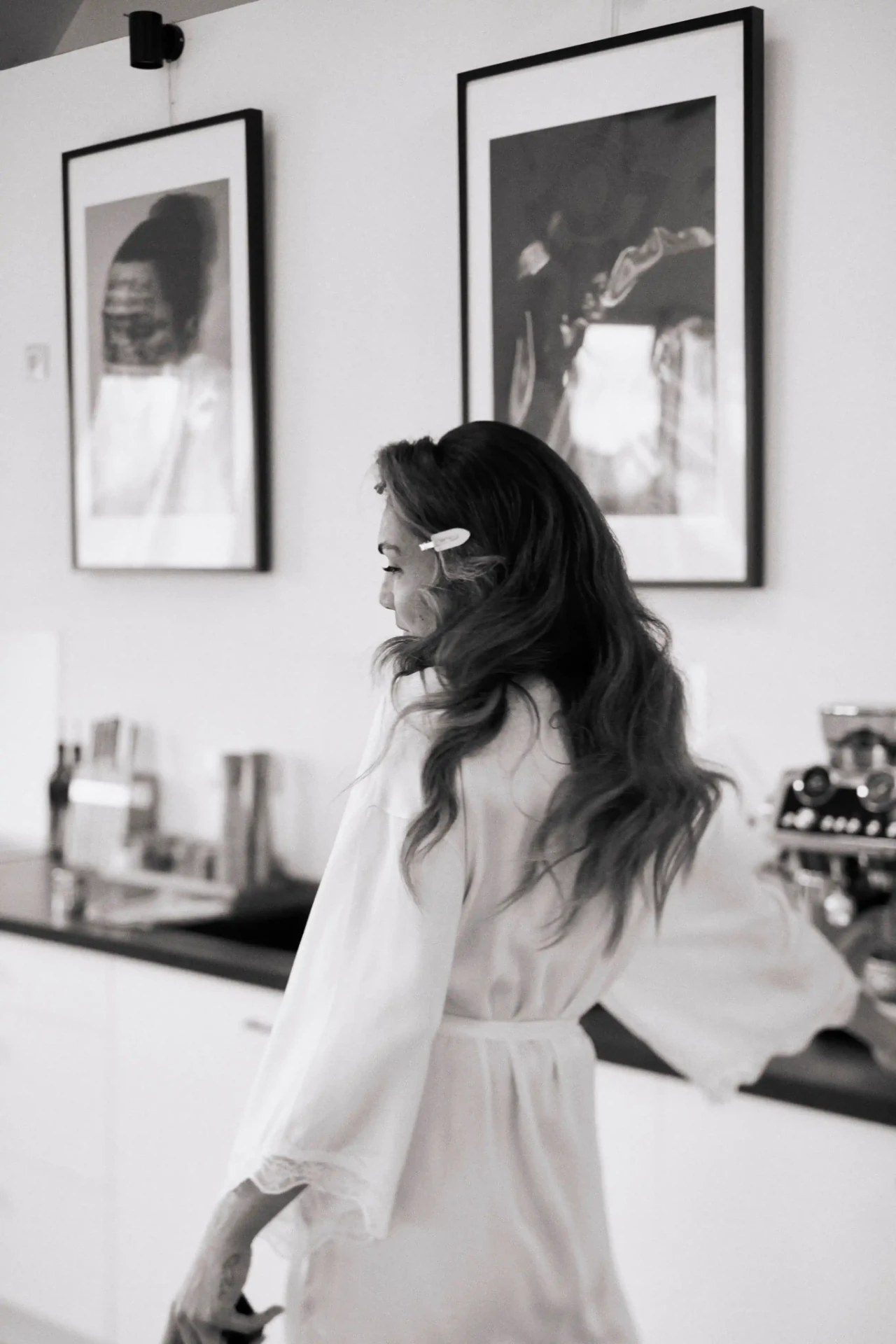 Bride in a white dress standing in a bright room by a window
