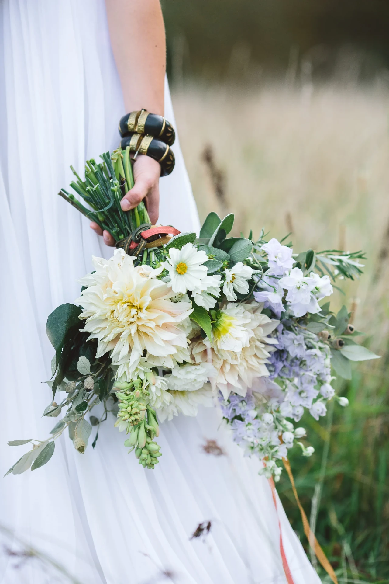 Close-up of a white bridal bouquet with large flowers and green foliage