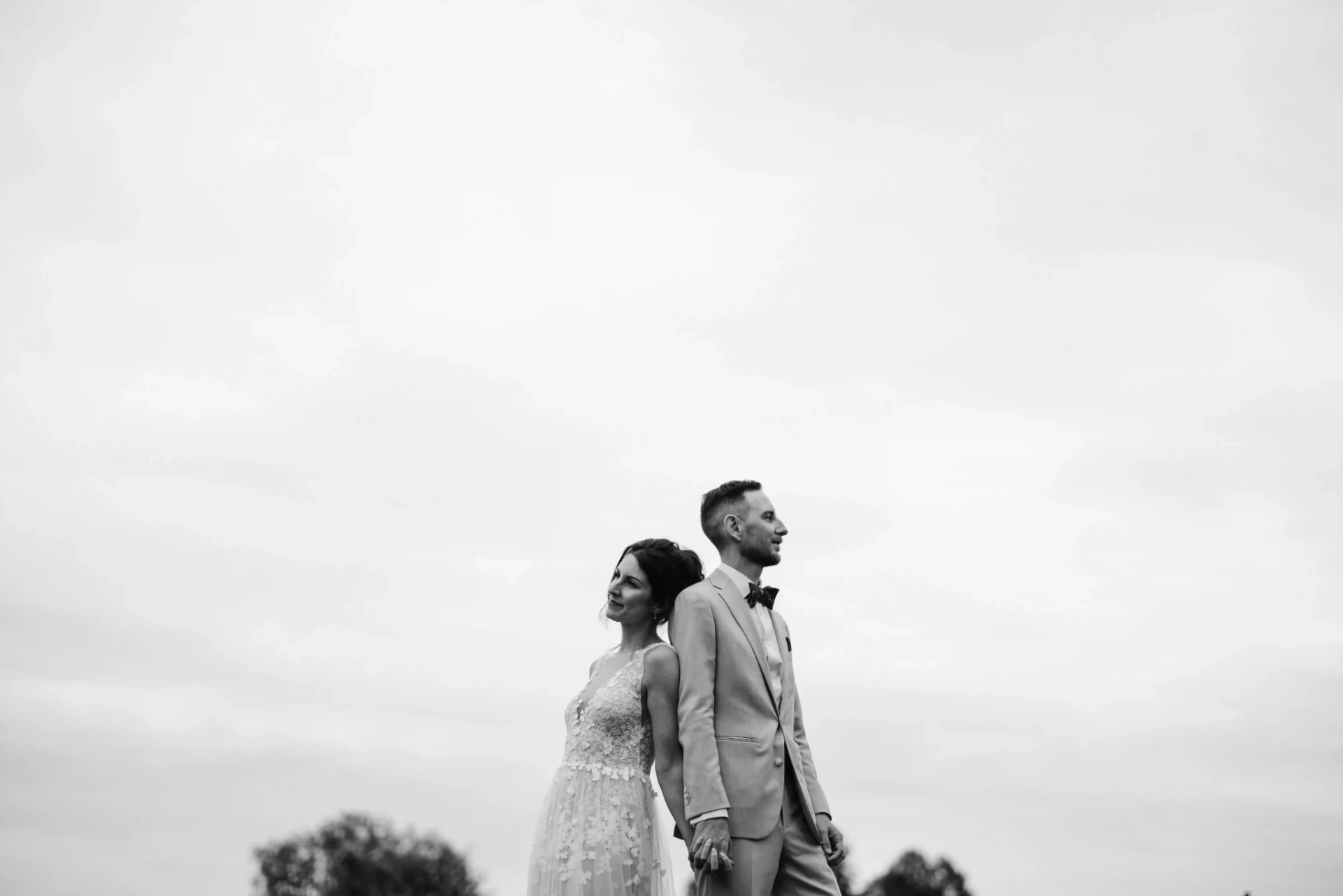 Bride and groom posing for a black-and-white portrait outdoors