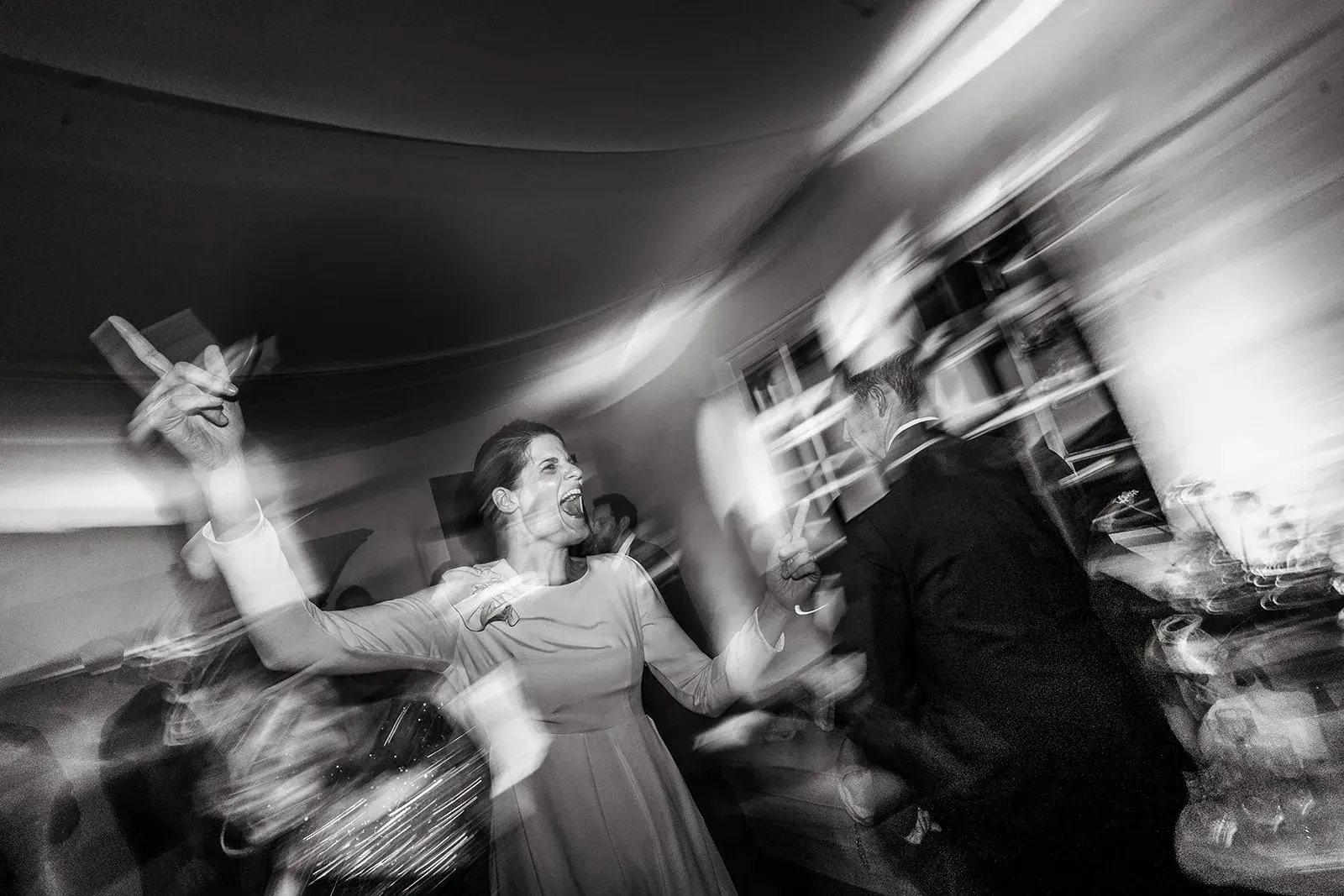 Black-and-white photograph of guests celebrating on the dance floor