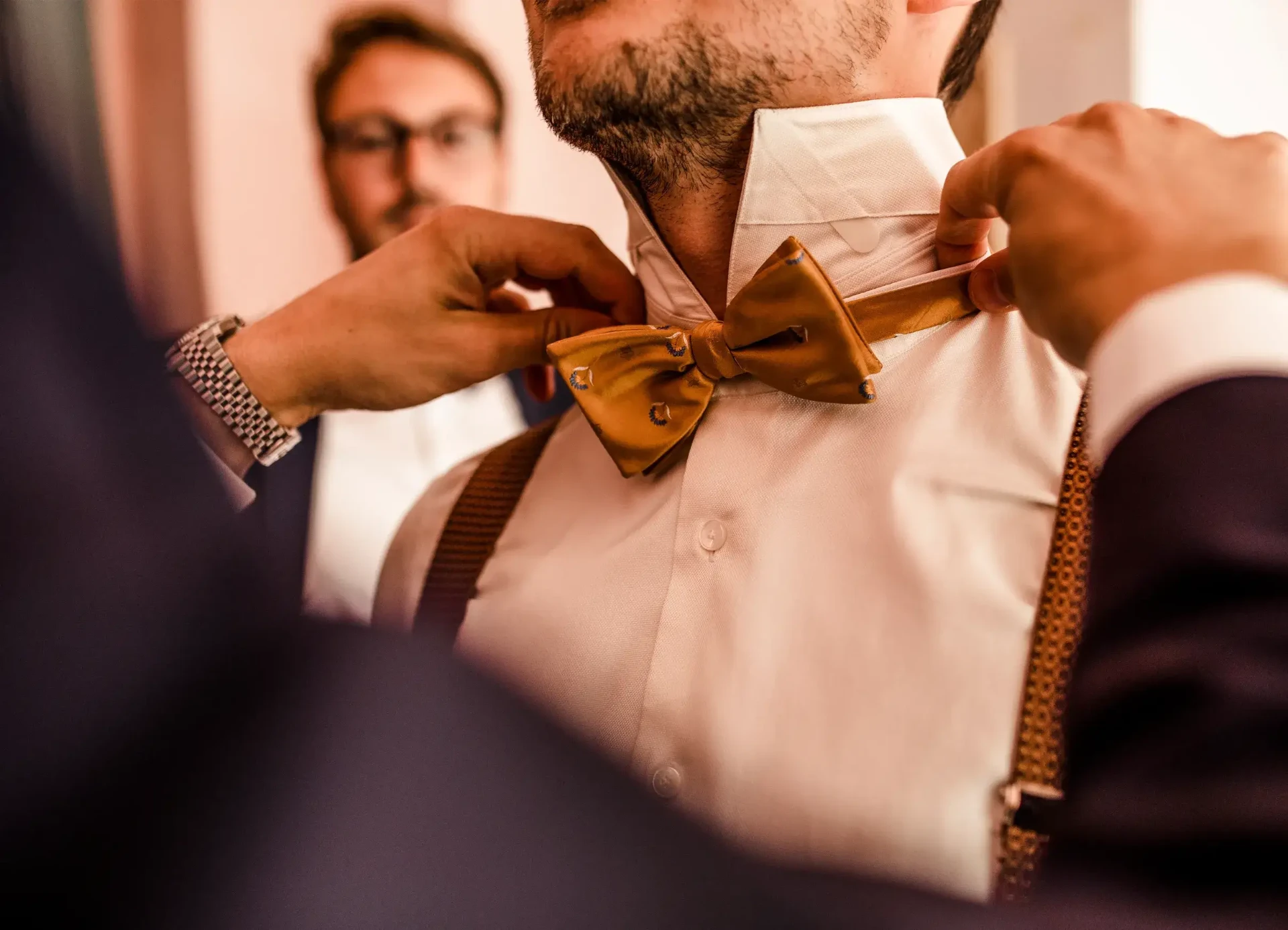 Close-up of the groom having his bow tie put on