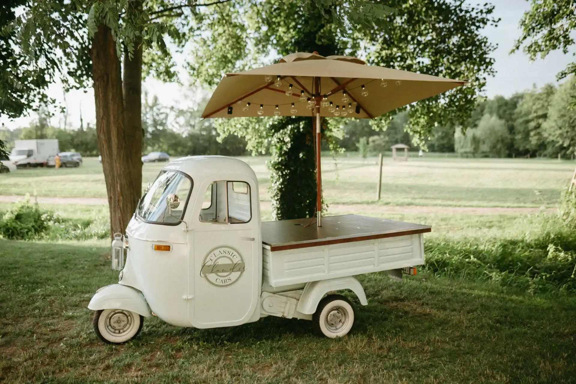 White drinks cart in a garden beneath trees