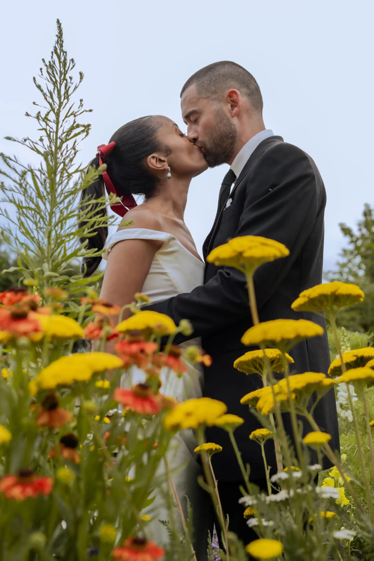 Wedding couple kissing among yellow flowers