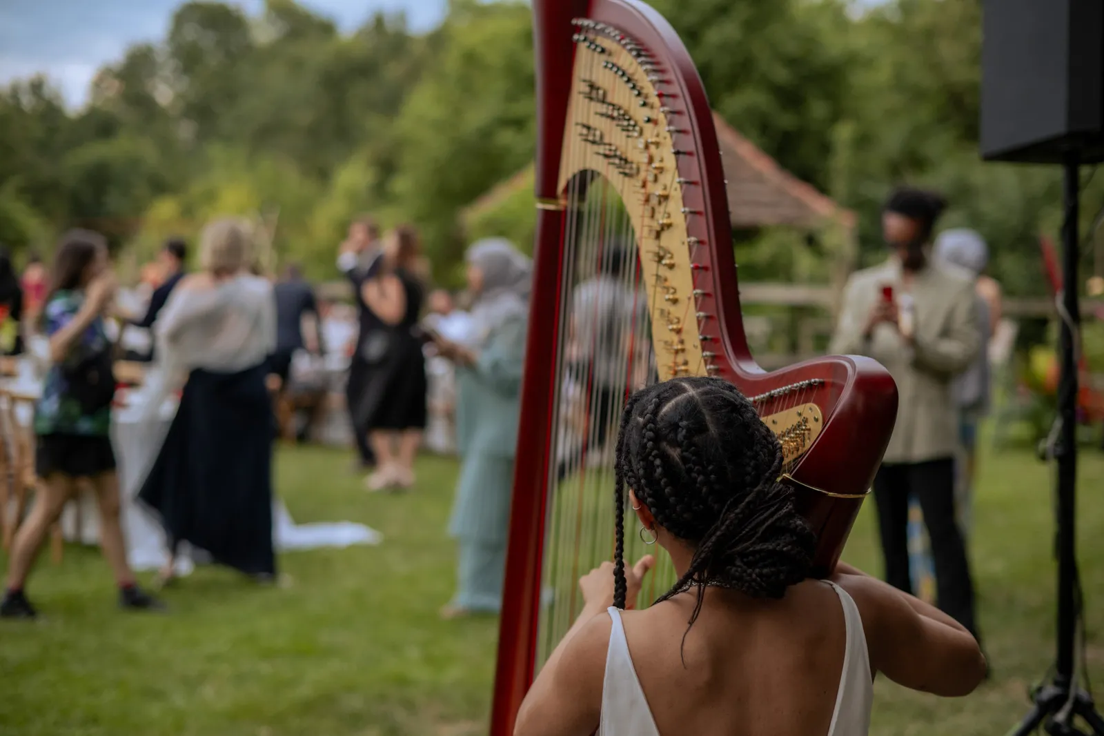 Harpist performing at an outdoor garden wedding