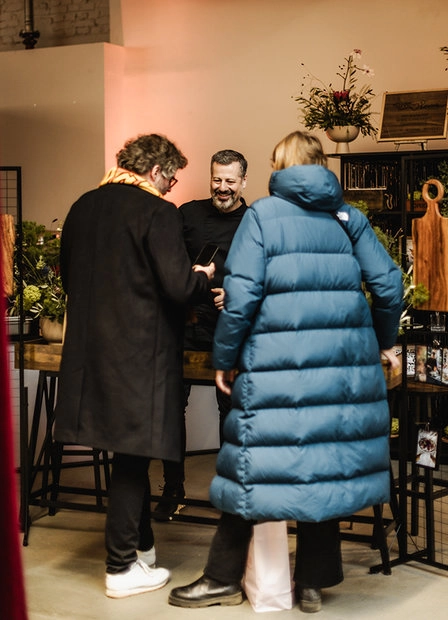 Visitors in winter coats at an exhibition stand