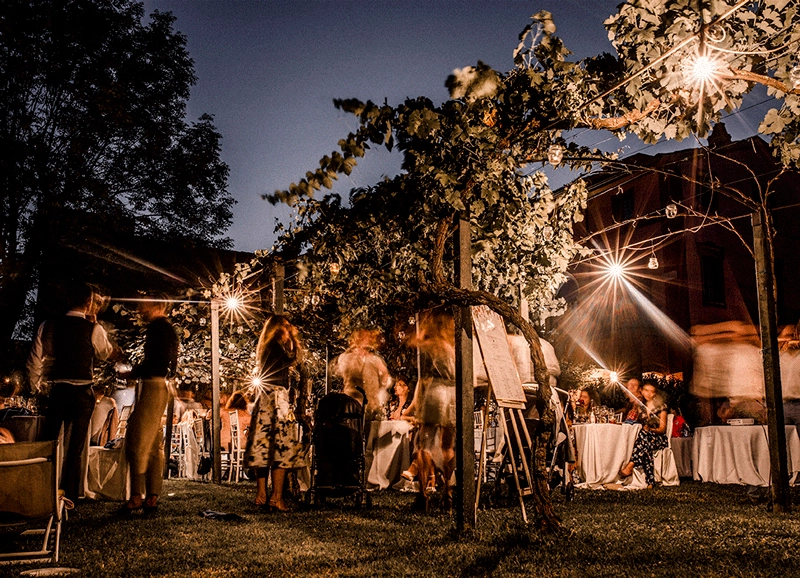 Guests celebrating outdoors beneath string lights