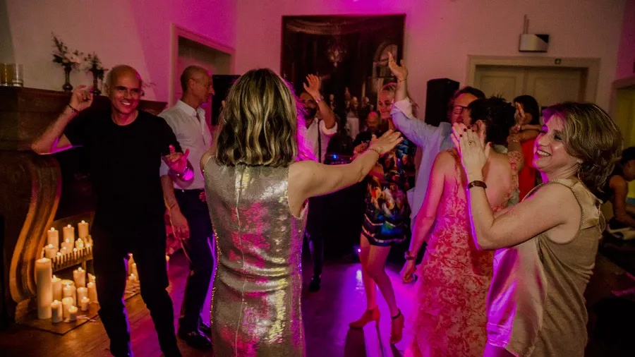 Bride and groom with guests at an indoor wedding celebration
