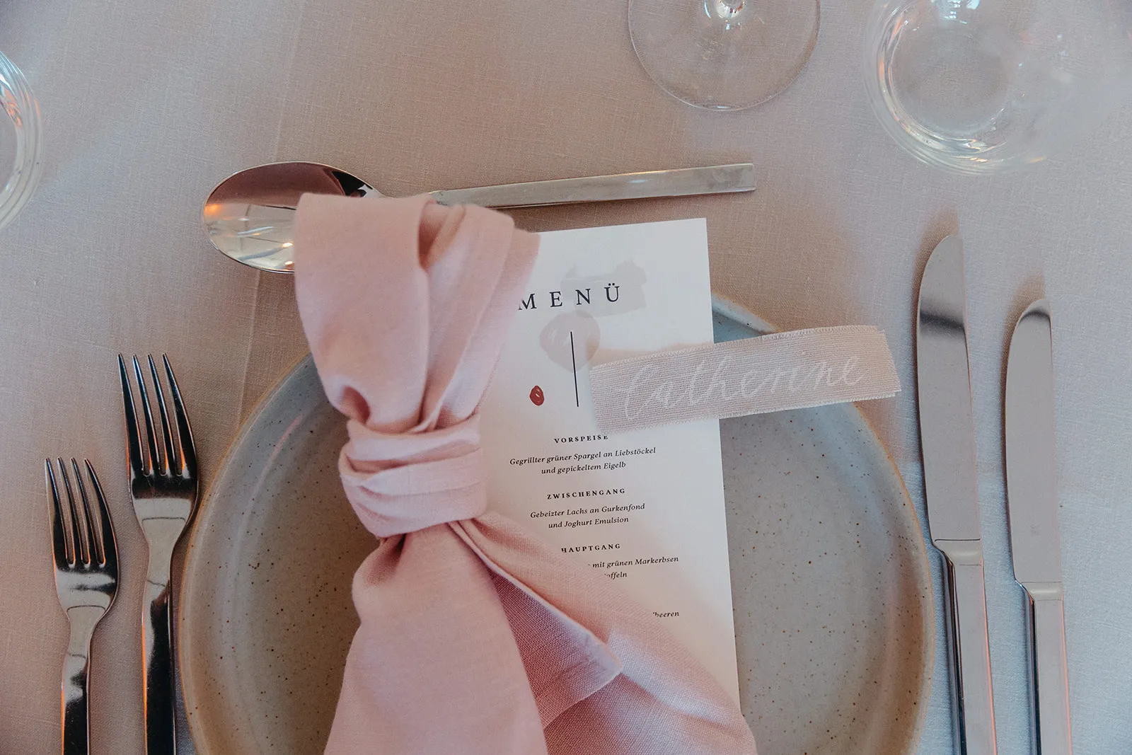 Pink wedding details and stationery on a light surface