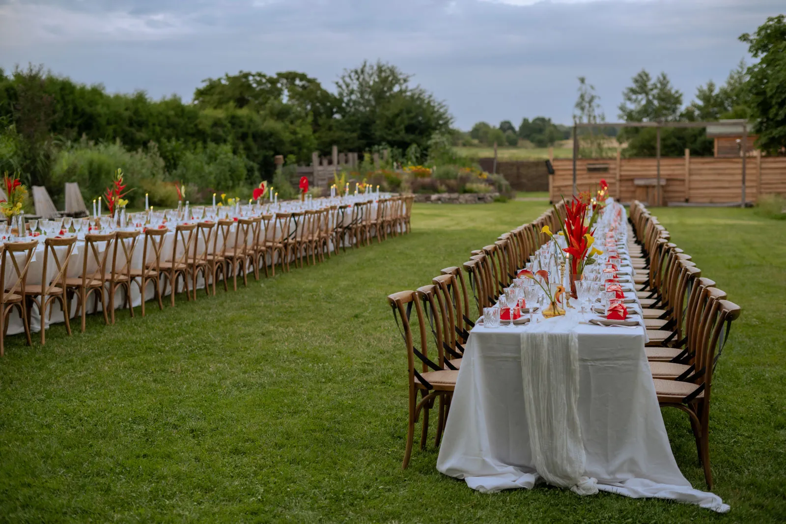 Long wedding tables arranged on a green meadow before dinner