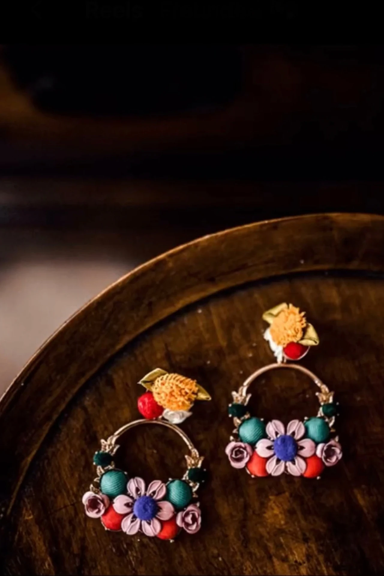 Colourful statement earrings against a dark background