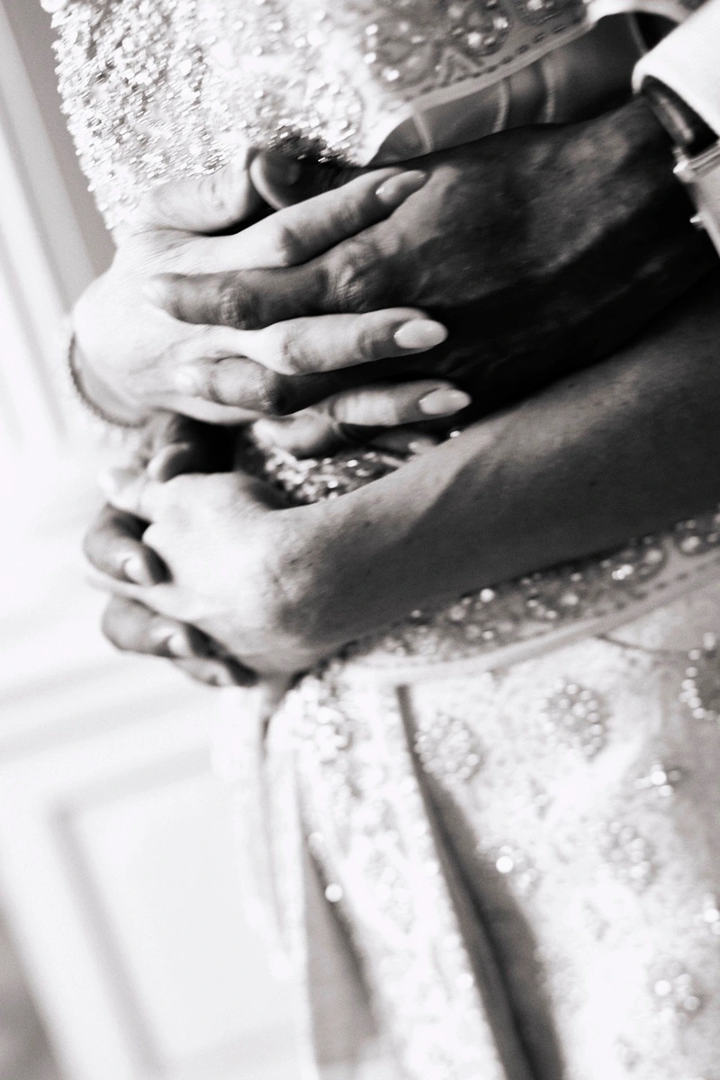 Close-up of two hands with jewellery and embroidered fabric