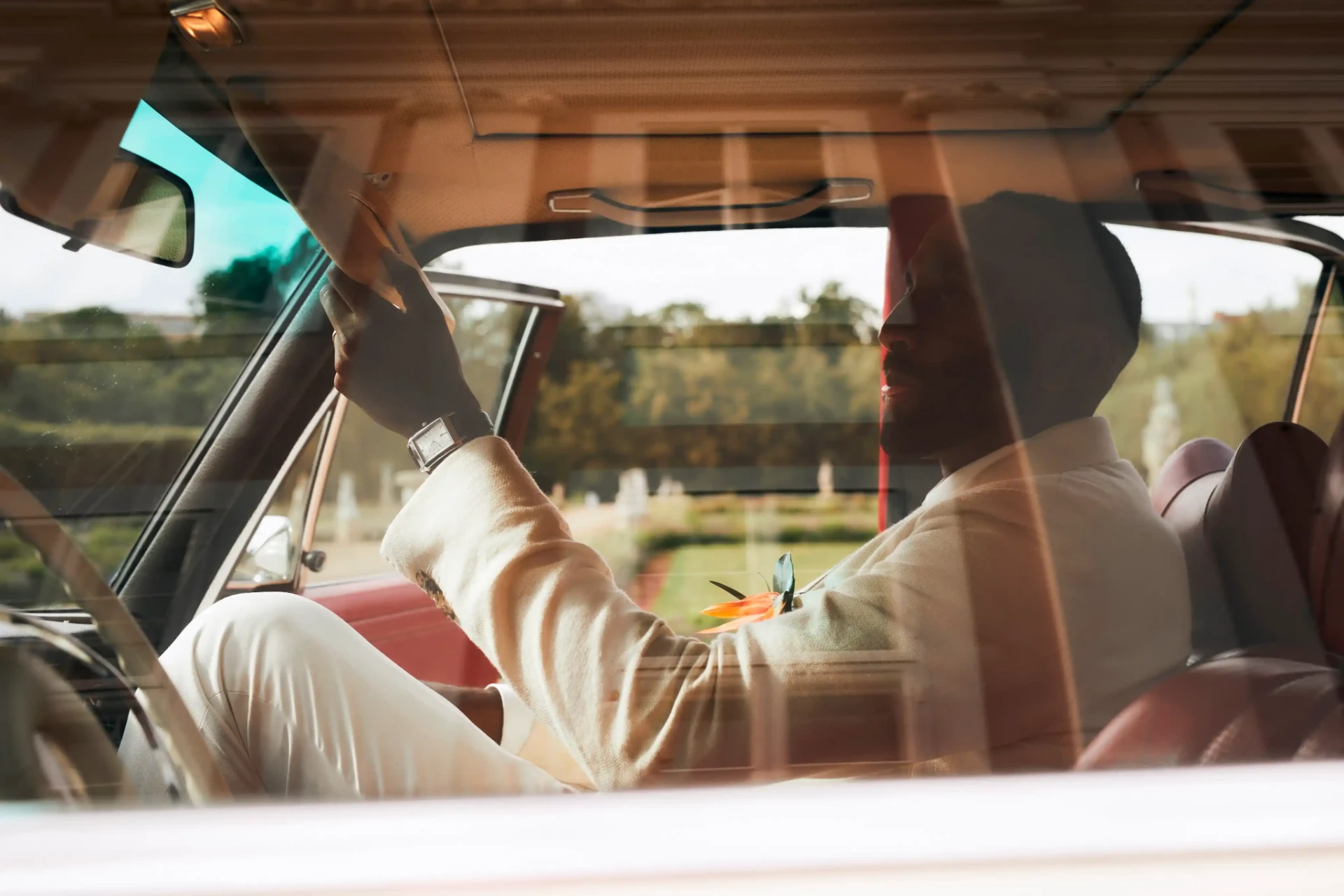 Wedding couple seated in a vintage car and seen through the car window