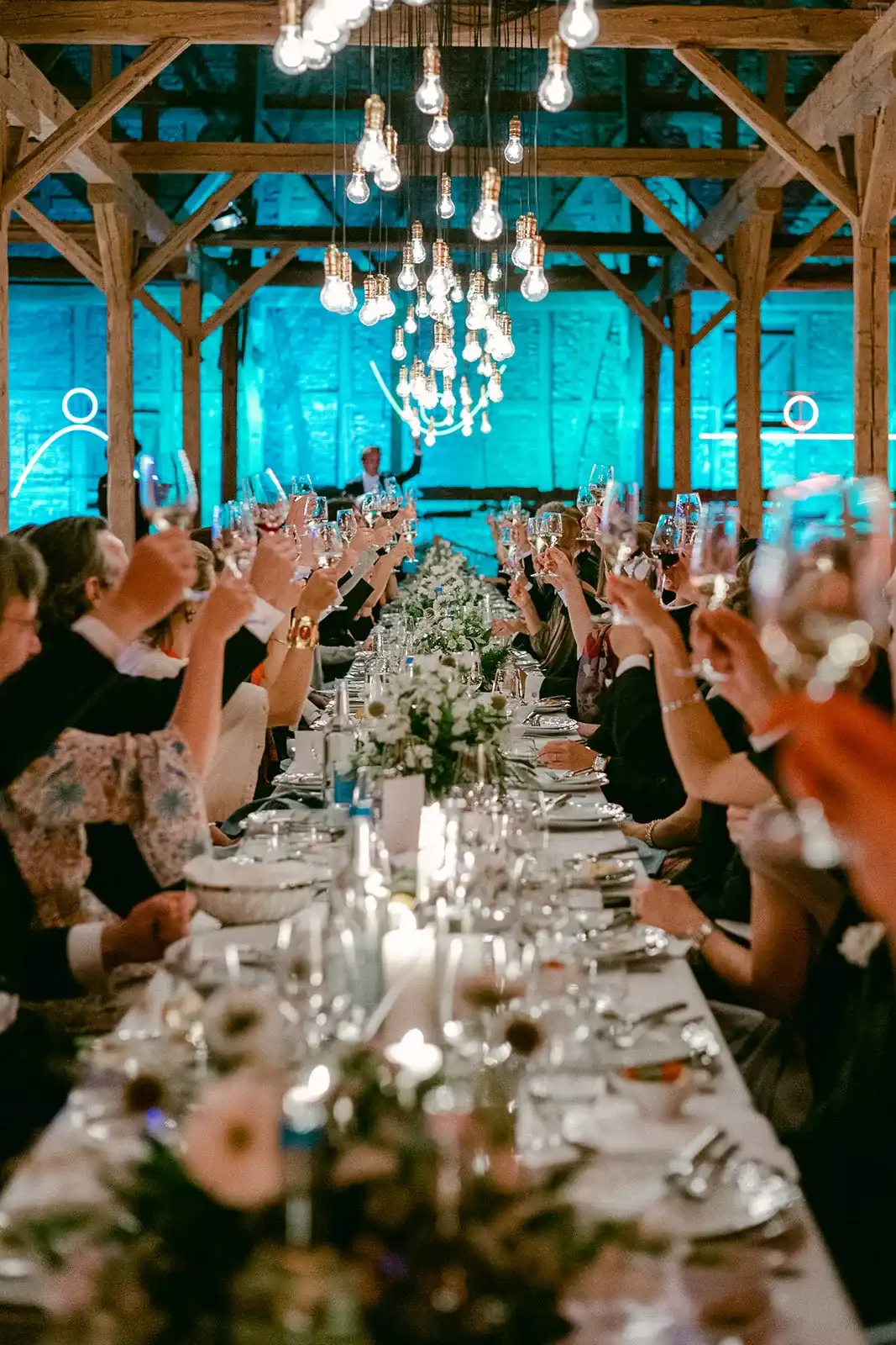 Wedding table in a barn with turquoise lighting and suspended lights