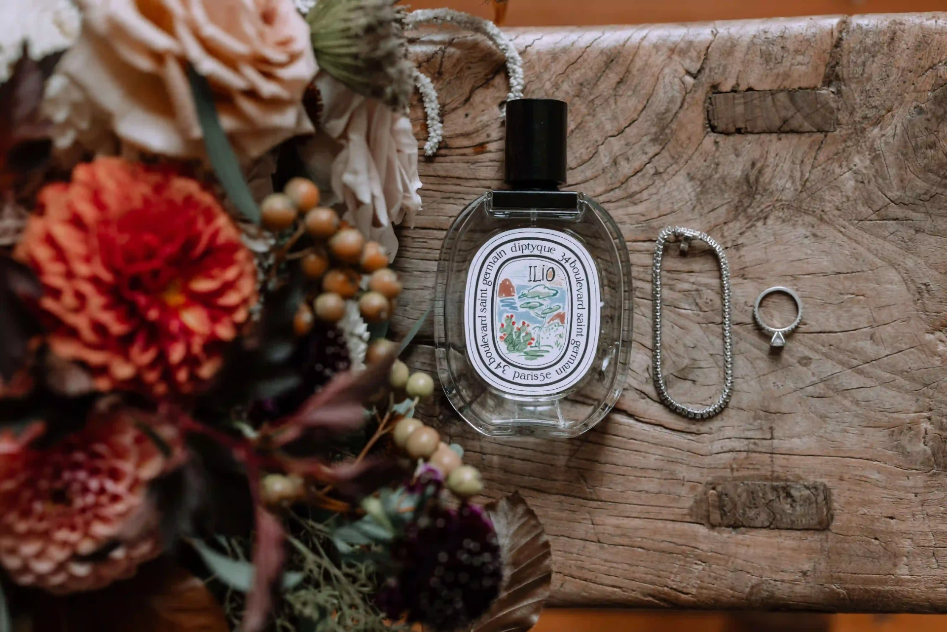 Wedding accessories and perfume on a rustic table