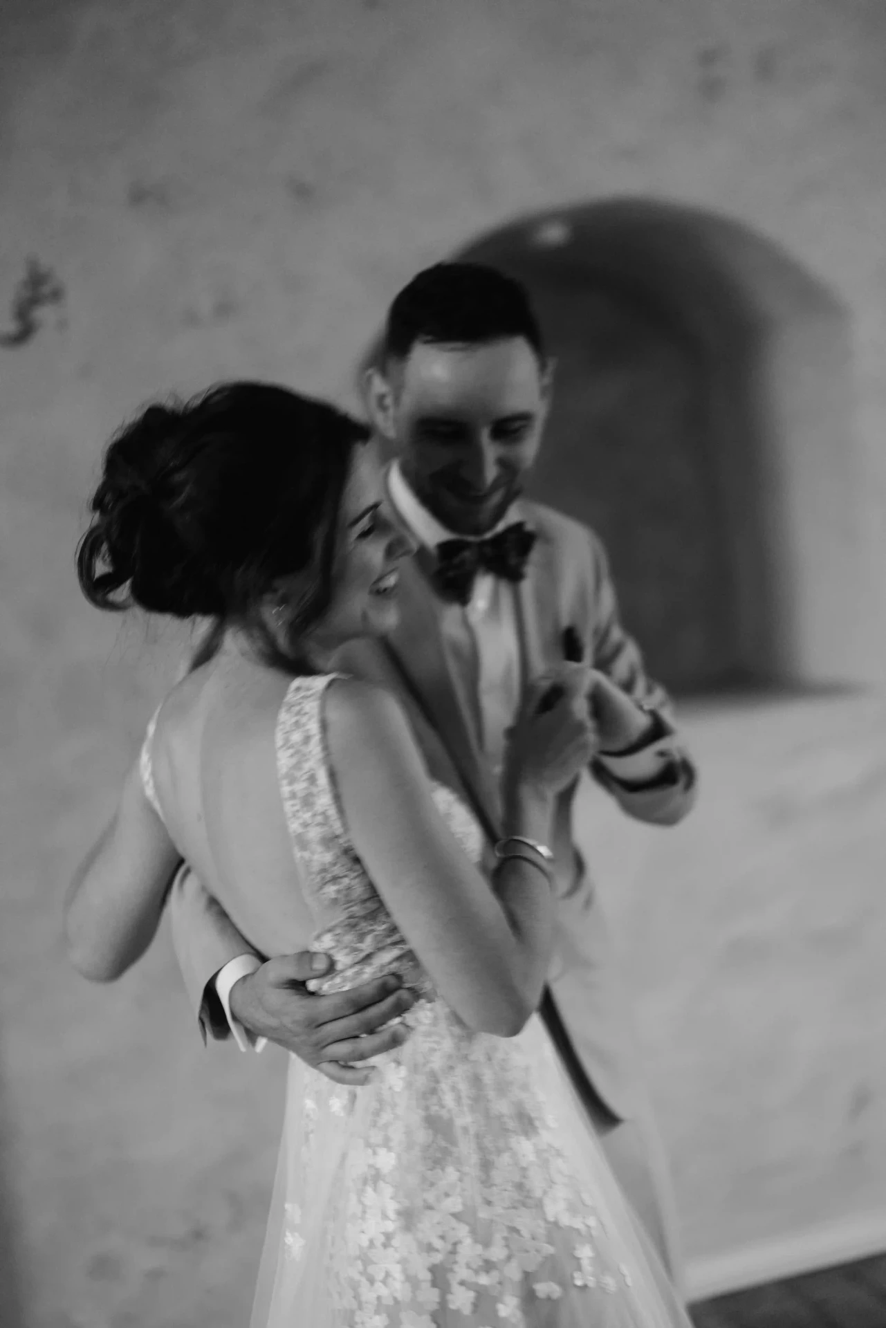 Bride and groom dancing in a close embrace, black-and-white photograph