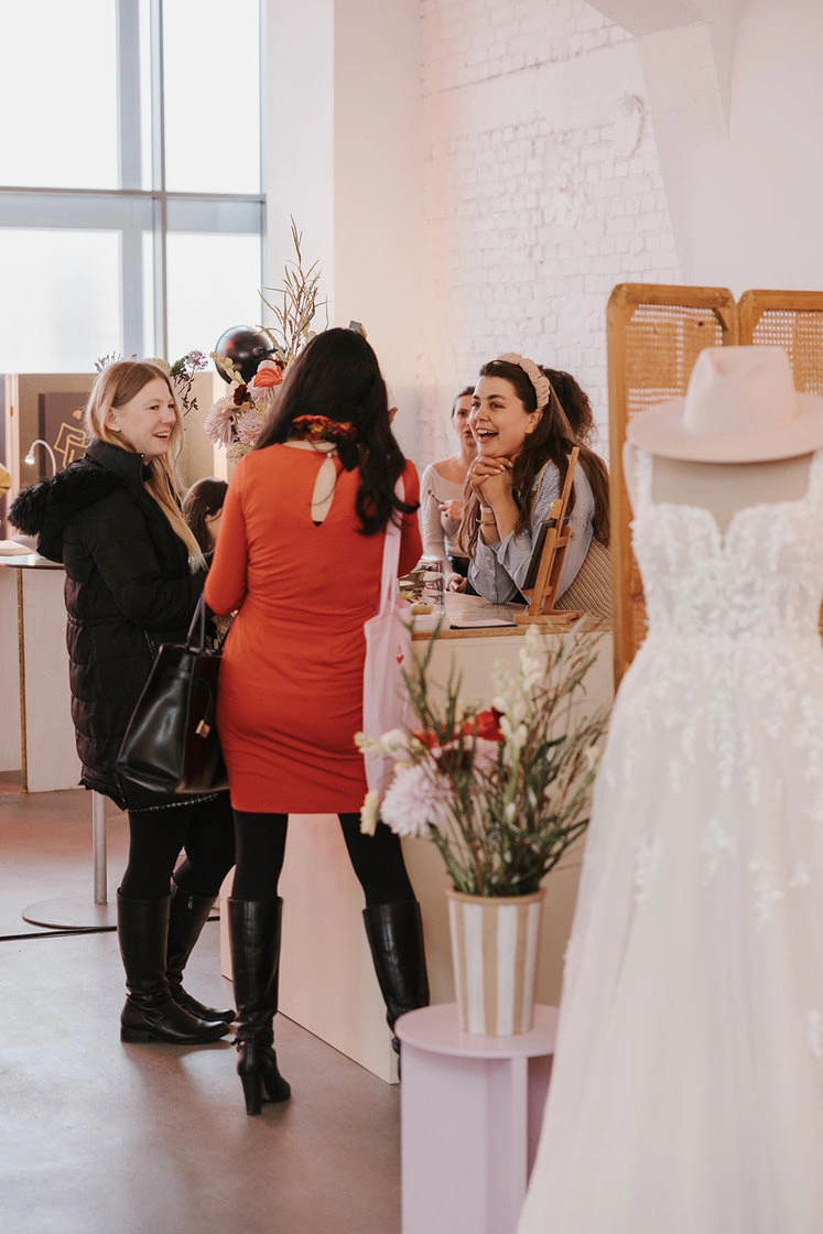 Two female visitors standing and talking in a bright exhibition space