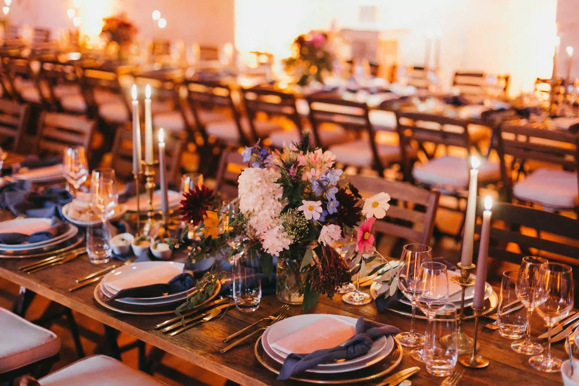 Long wedding table with abundant flowers and candles