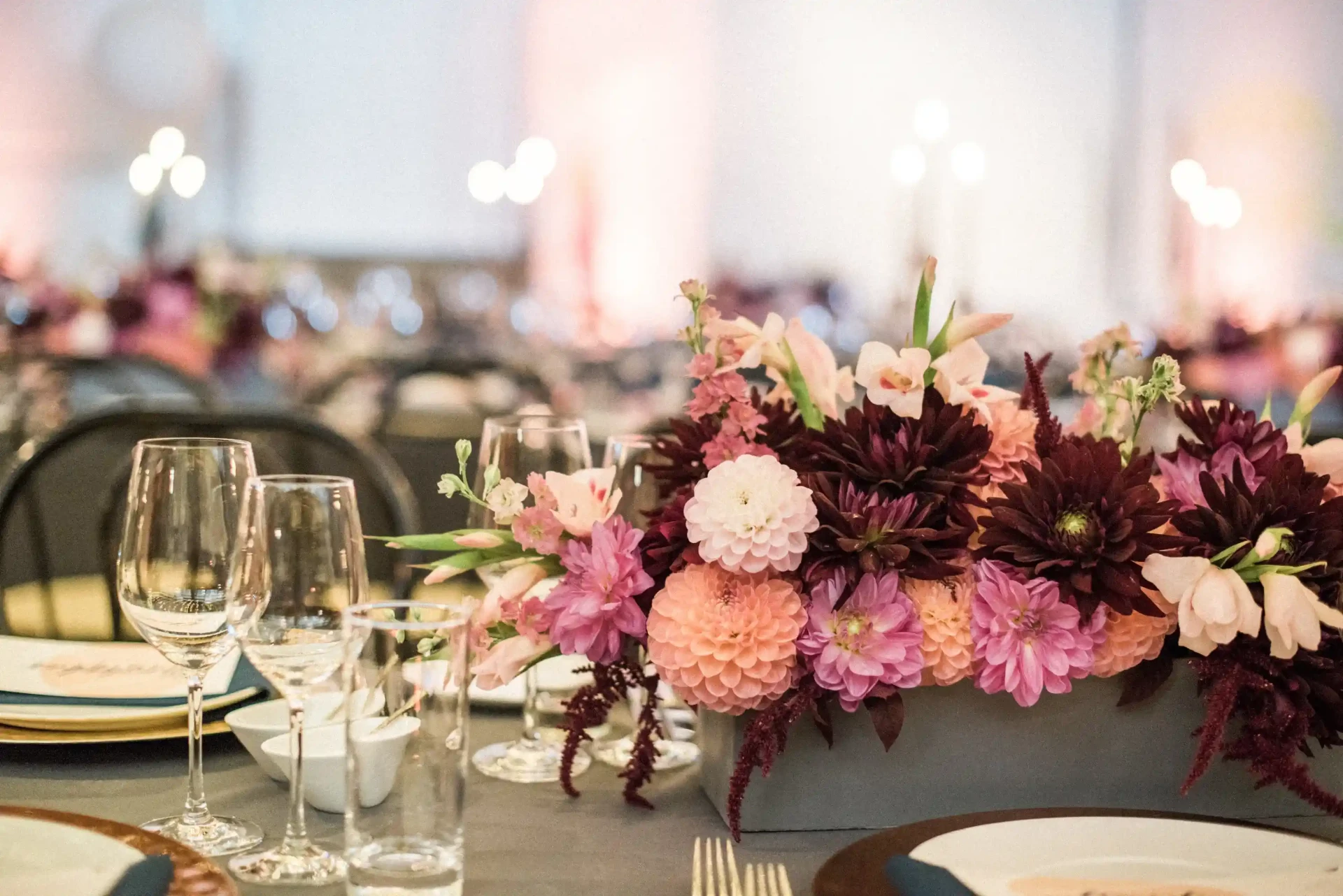 Floral arrangement with pink and burgundy flowers on a wedding table