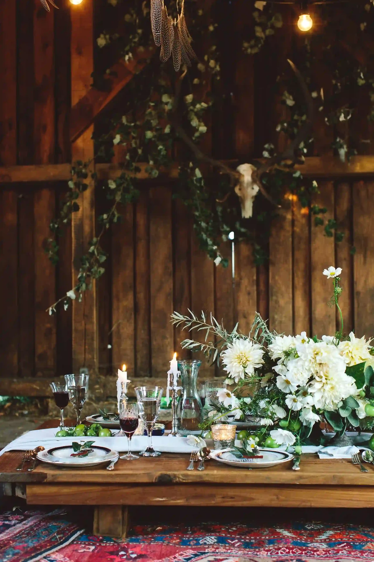 Wedding table set with white florals, plates and glasses