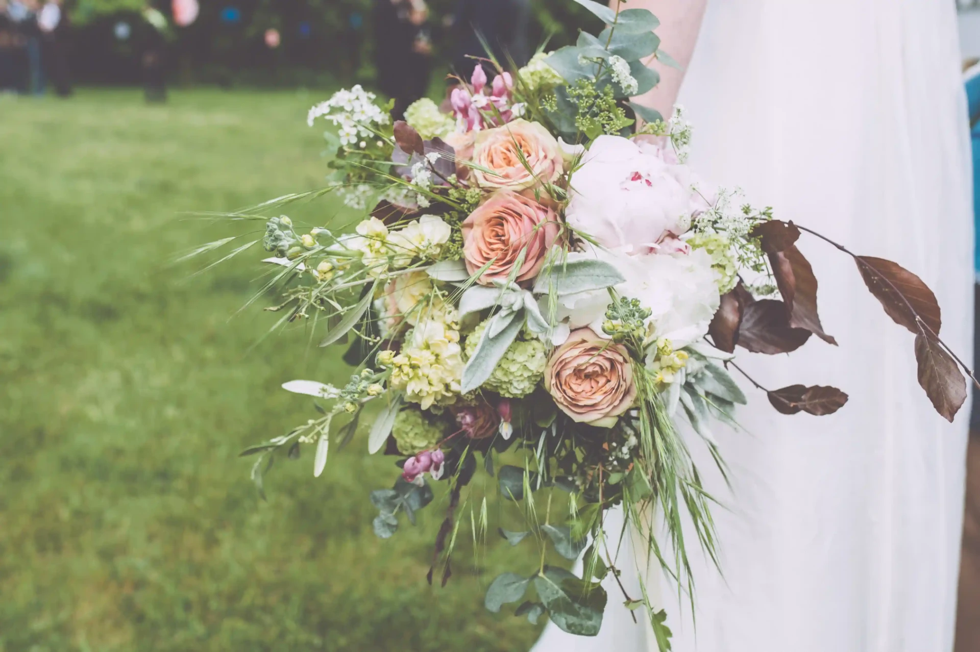 Bridal bouquet with pink and cream flowers on a lawn