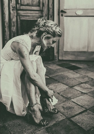 Bride sitting by a window in a light-coloured dress