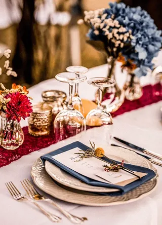 Detail of a wedding table with red flowers and plates