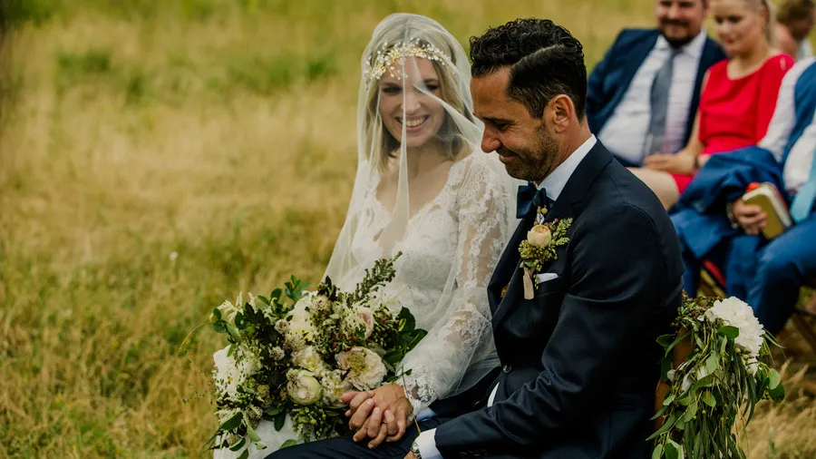 Bride and groom seated during an outdoor ceremony