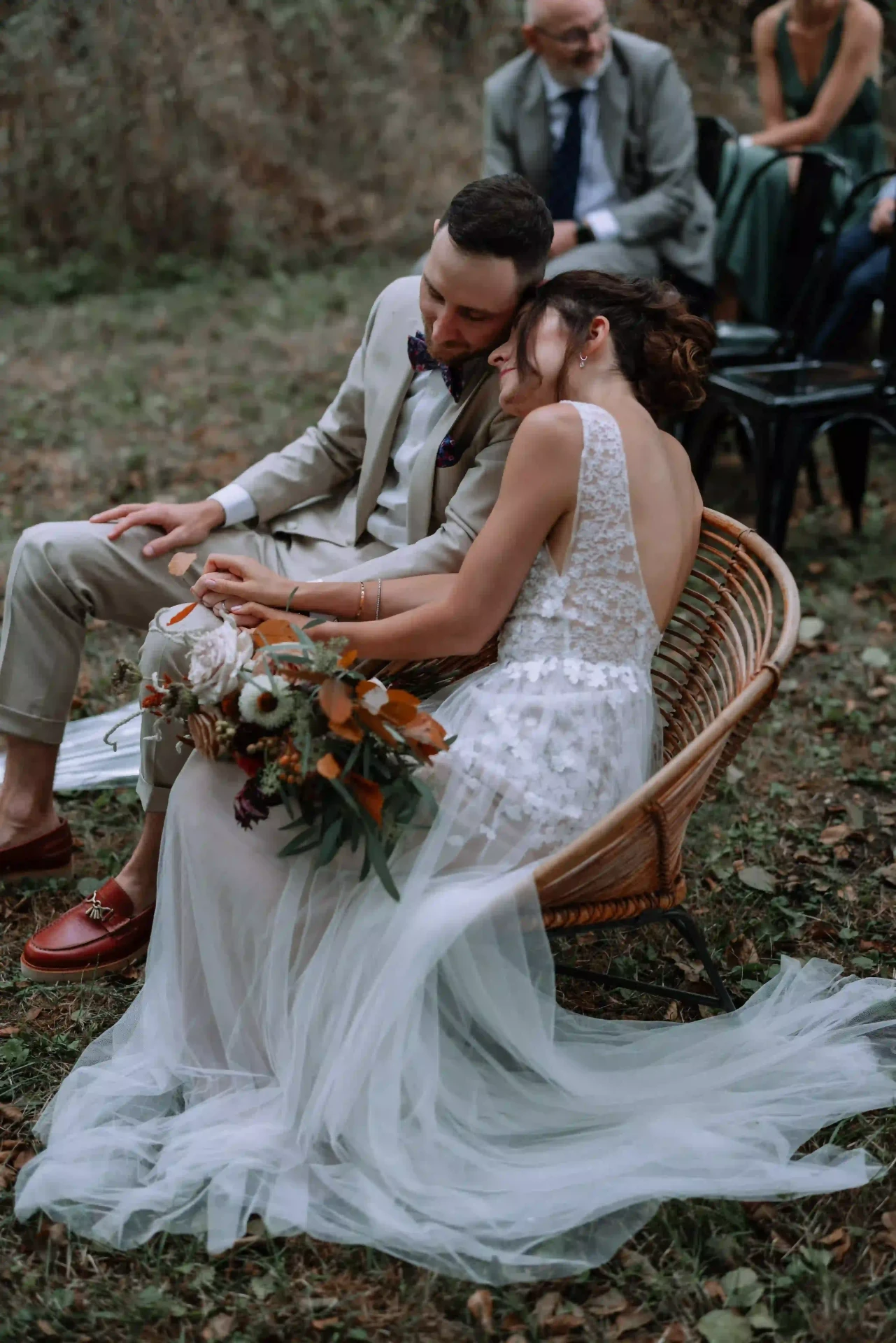 Bride and groom seated outdoors after the ceremony