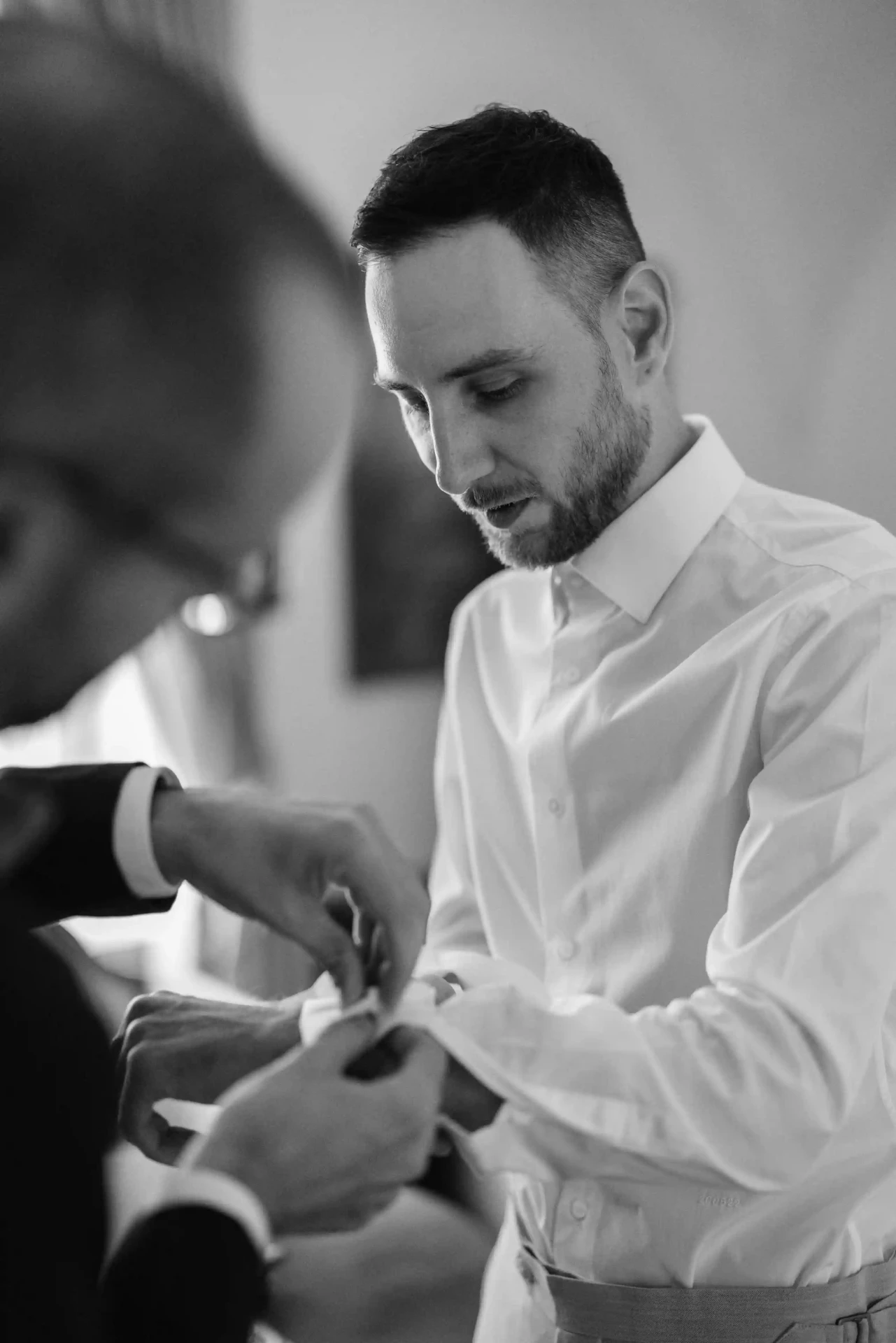 Groom adjusting his shirt before the wedding