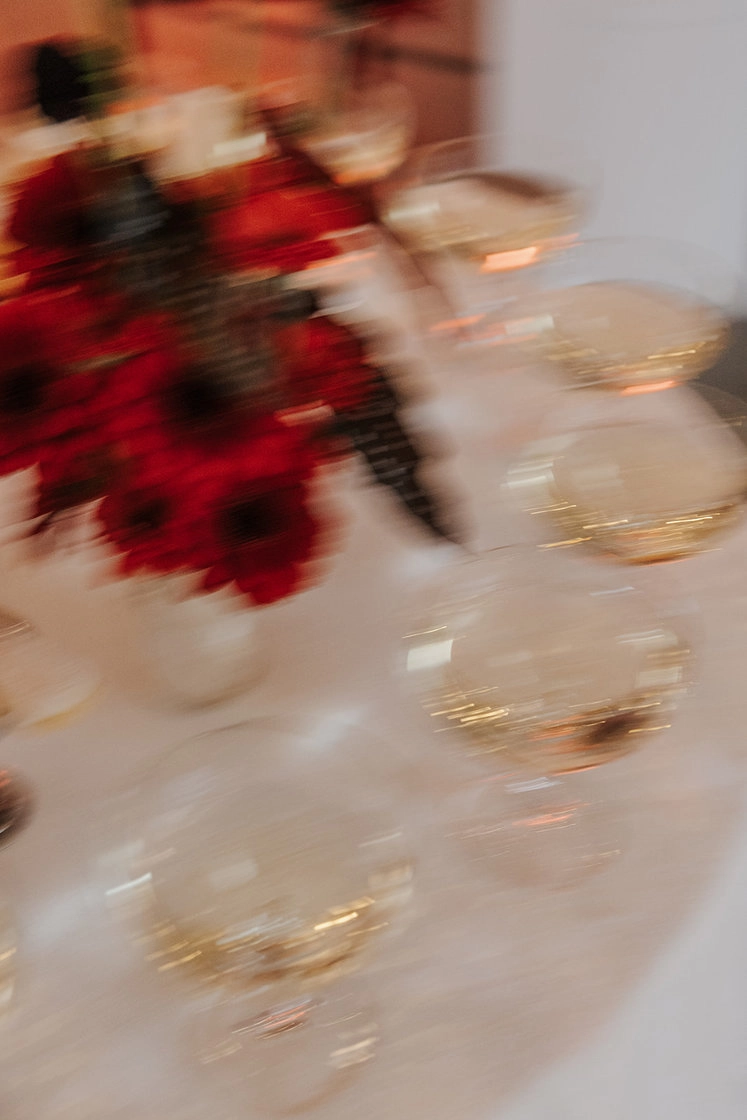 Detail of a table with red flowers and glassware
