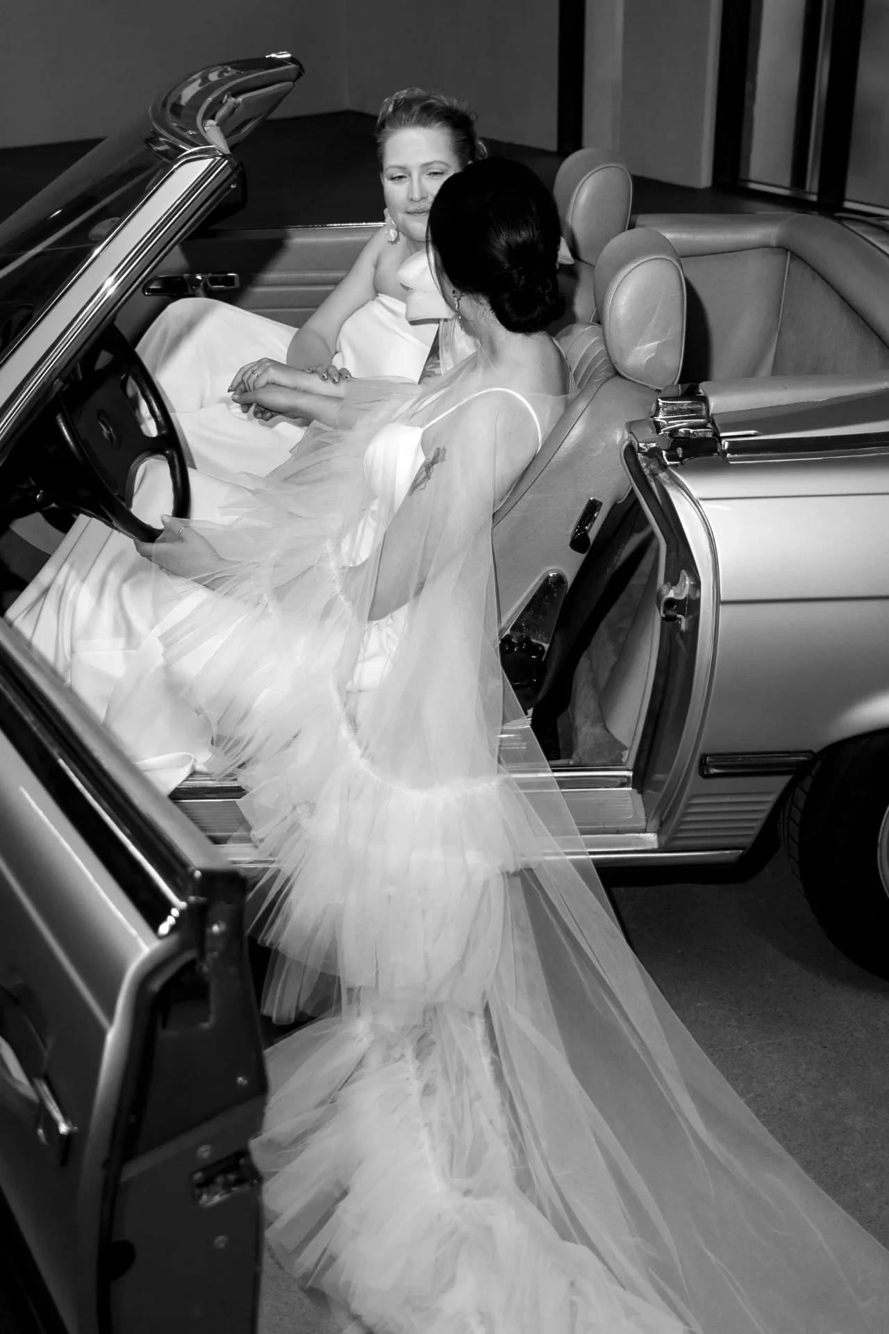 Wedding couple posing in a convertible