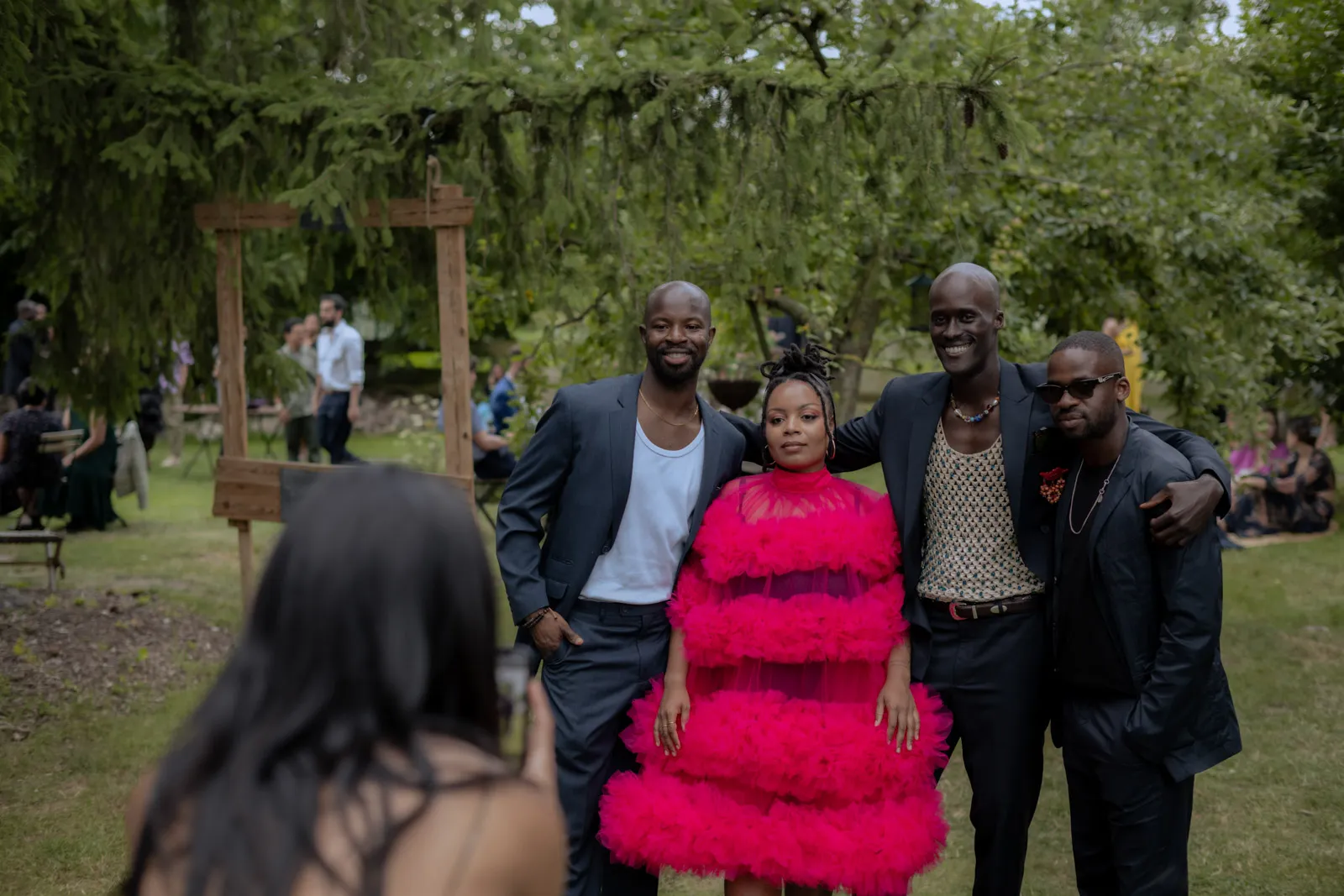 Wedding guests in colourful outfits in a garden setting