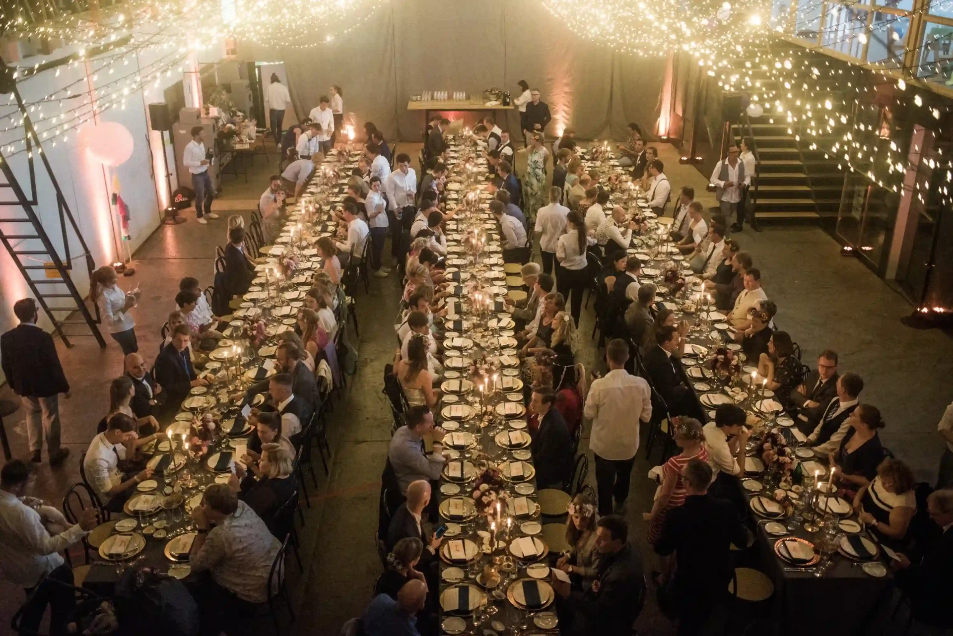 Aerial view of a long dinner table with guests in a large hall