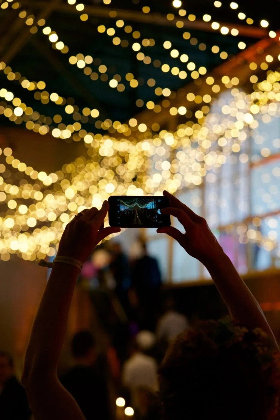 Guest photographing the illuminated decor above the wedding table