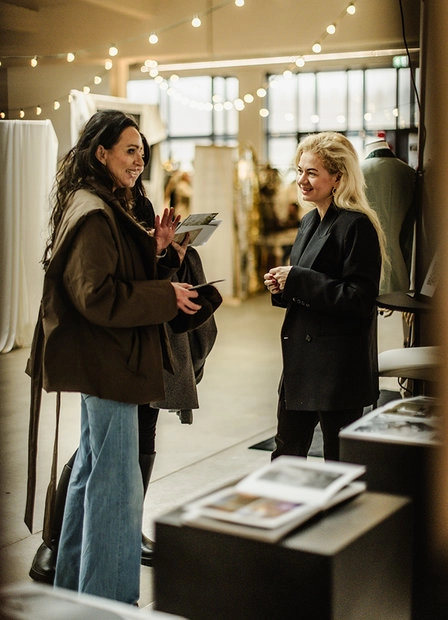 Two women looking at printed materials on a table