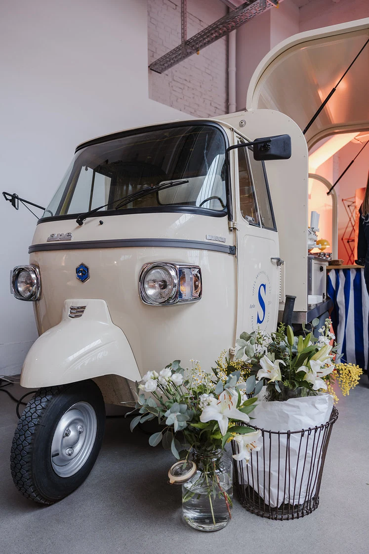 White vintage car decorated with flowers outside a building