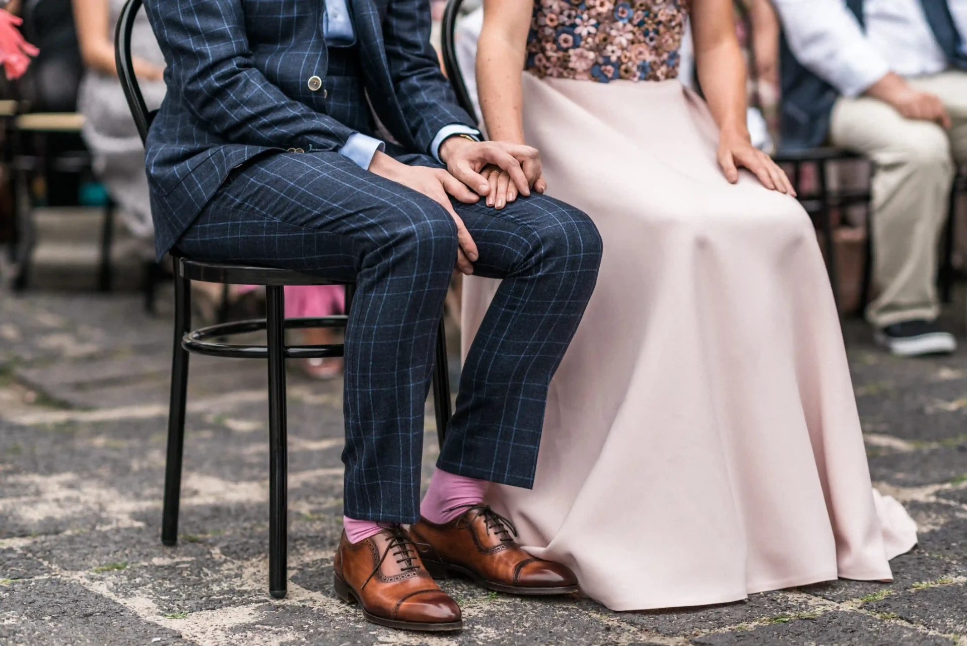 Wedding couple seated side by side, with the bride wearing a blush-pink dress