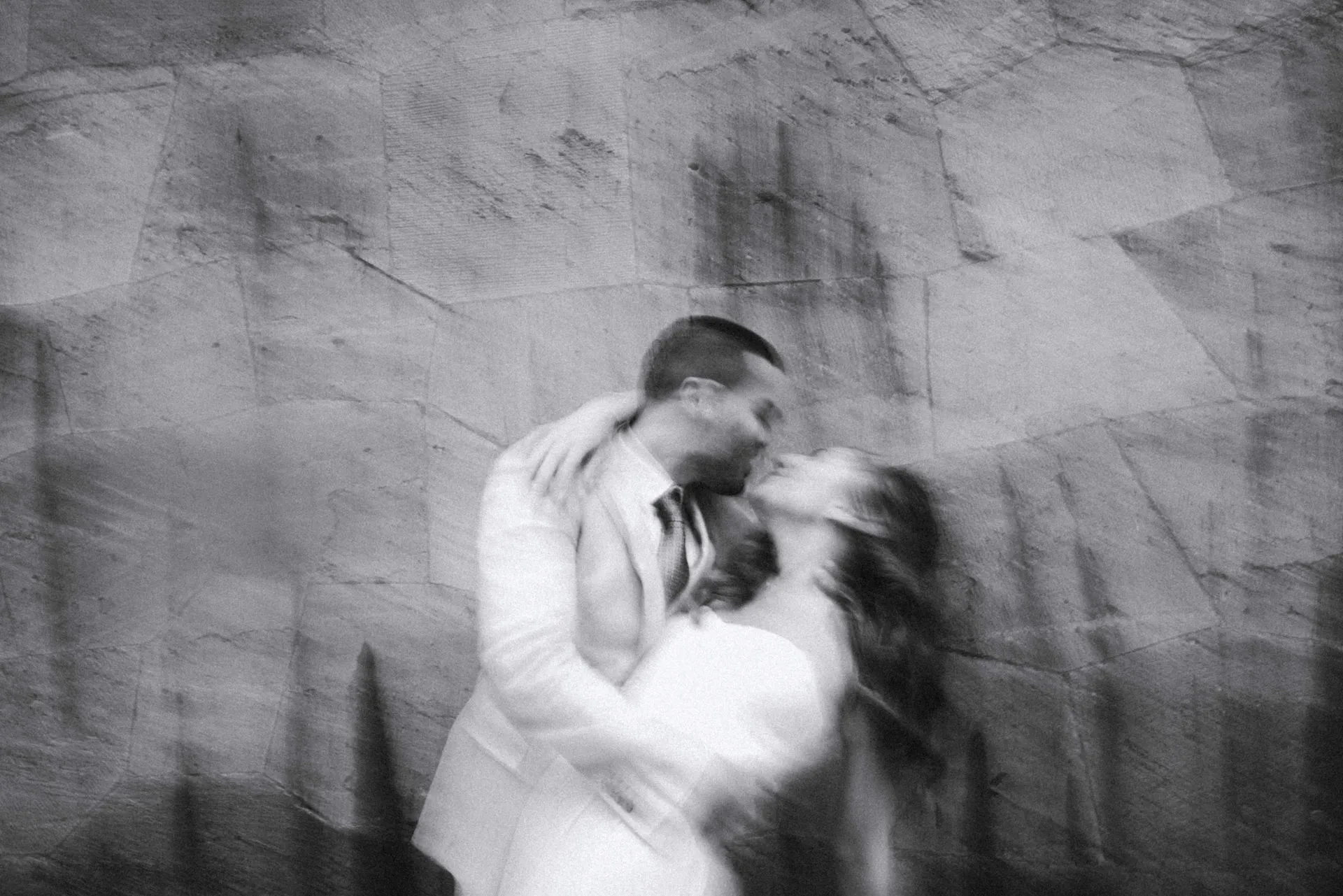 Bride and groom kissing in a black-and-white photograph