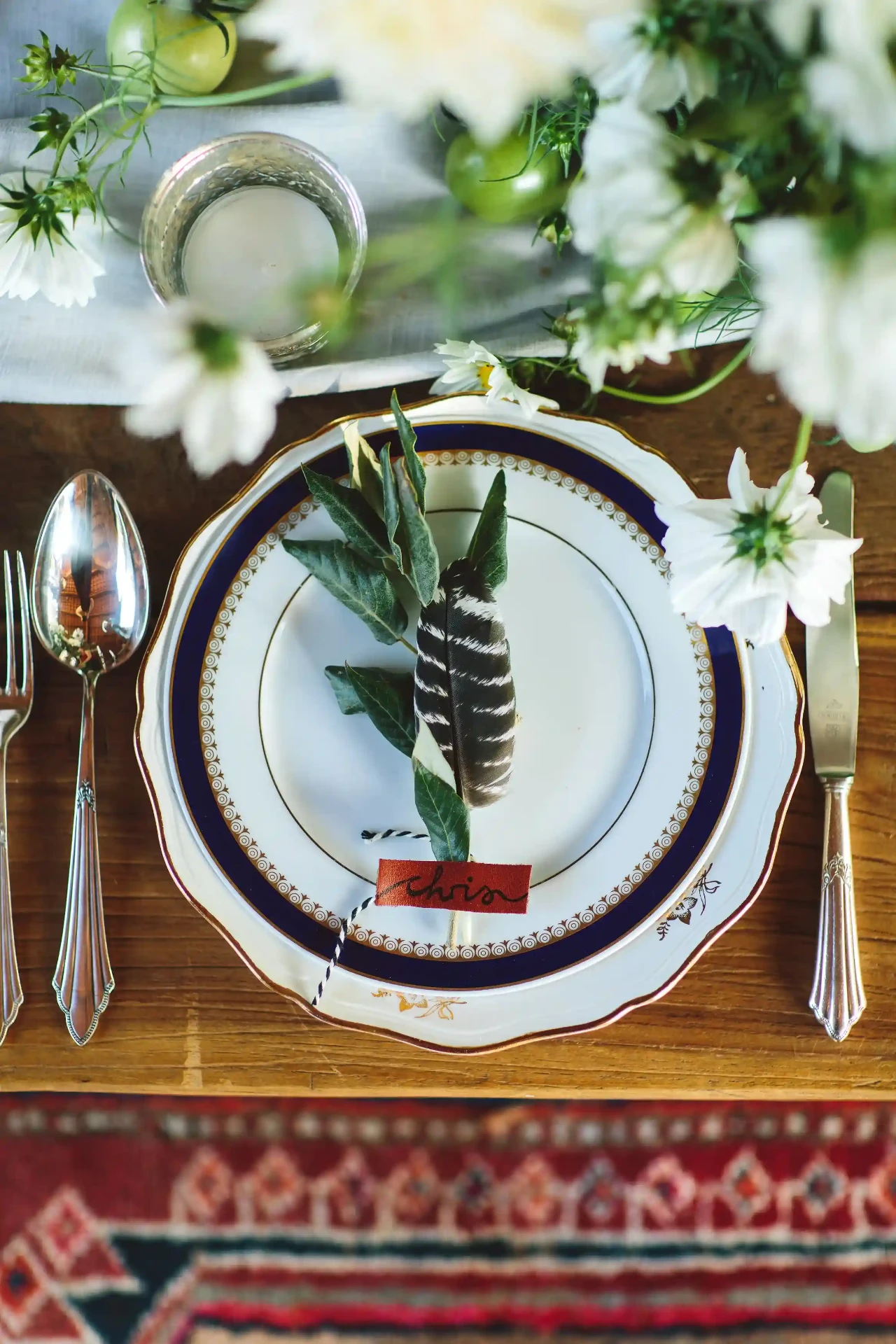 Wedding table detail with white flowers, candles and a wooden table