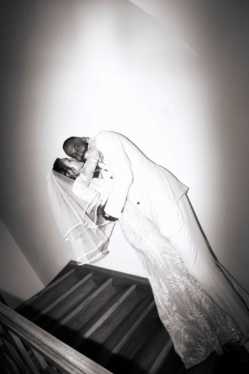 Bride in a white dress on a staircase, black-and-white photograph