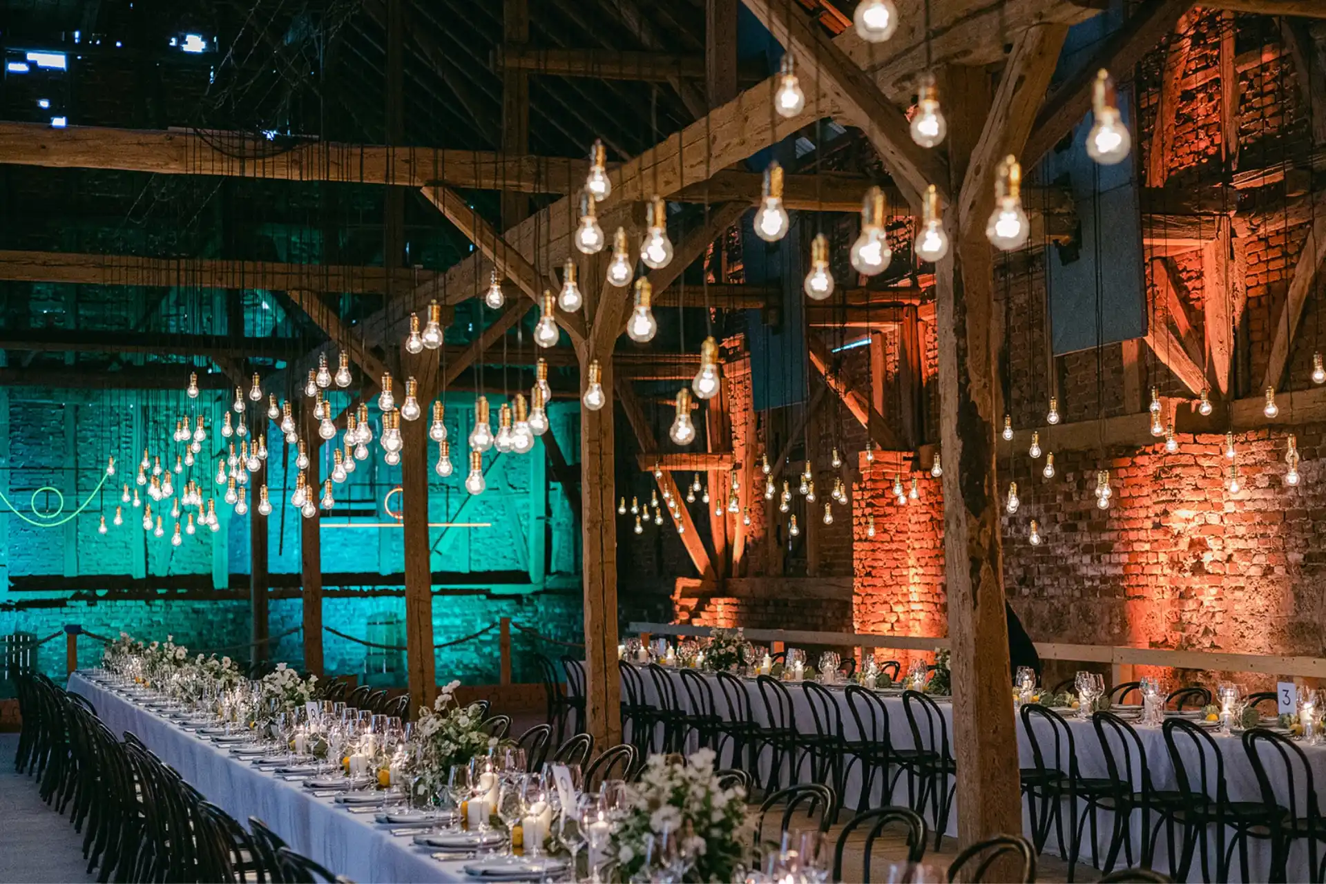 Wedding reception table in a barn with warm lighting and carefully arranged place settings