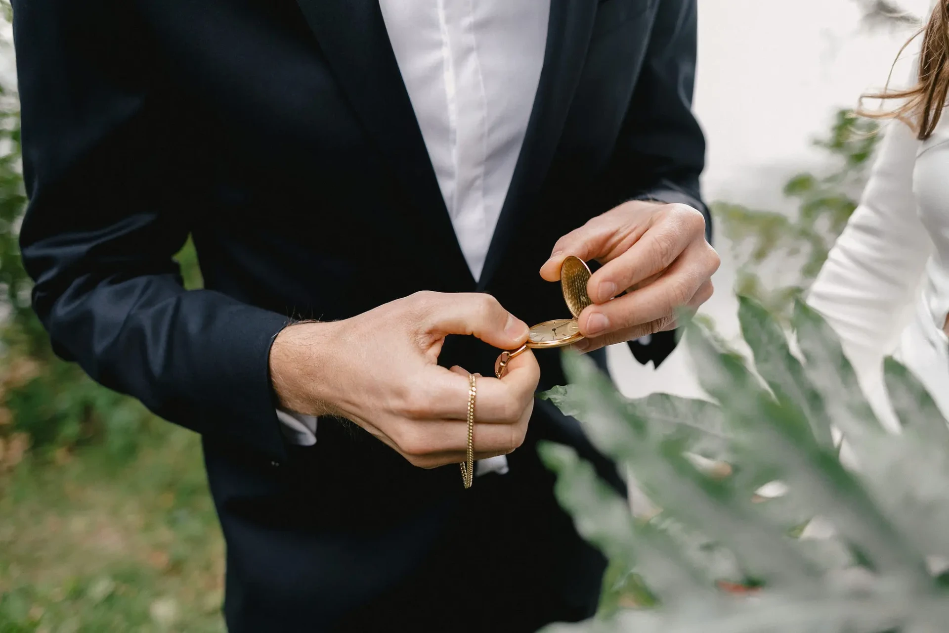 Groom adjusting his jacket beside the bride