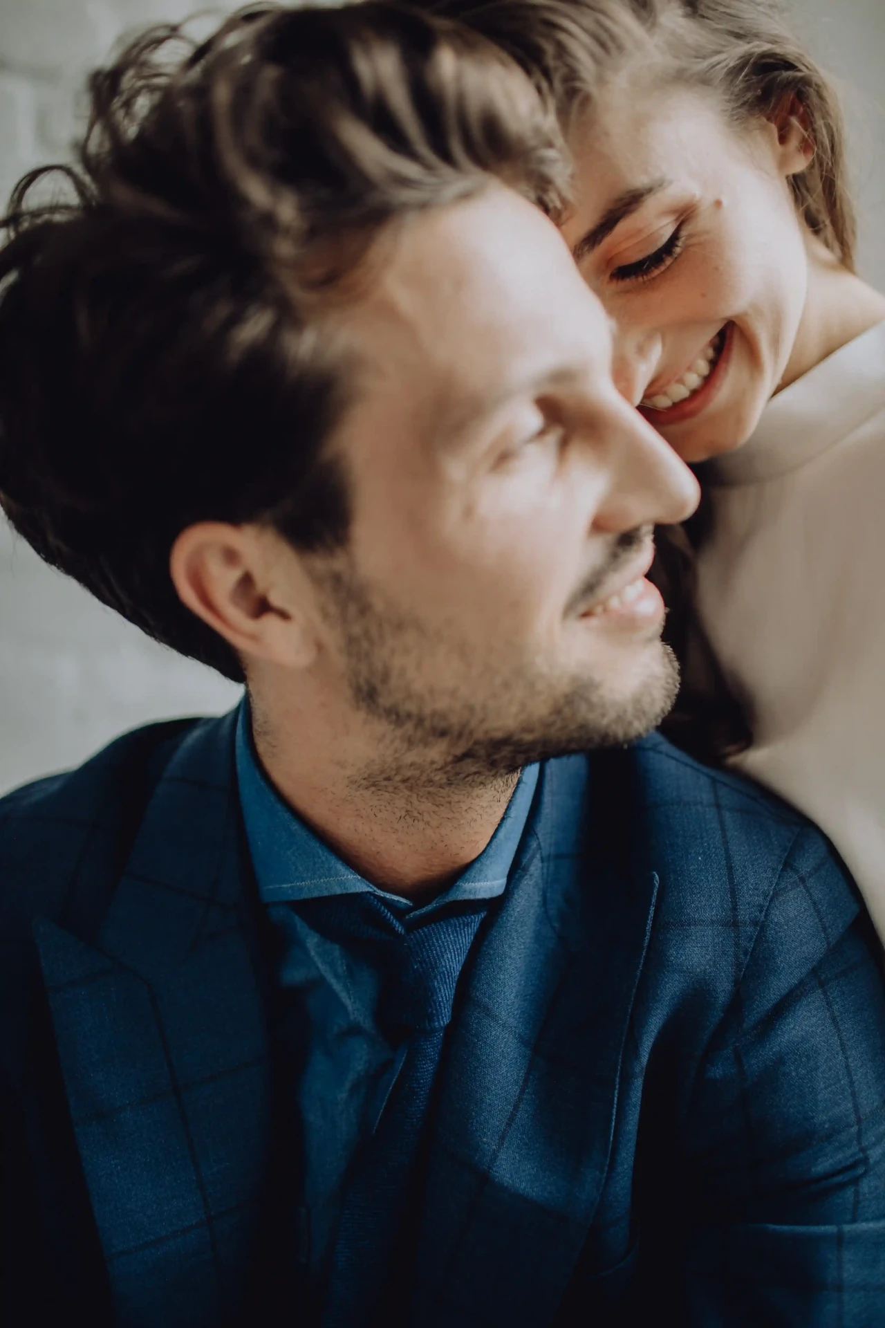 Close-up of the groom in a blue suit with his eyes closed