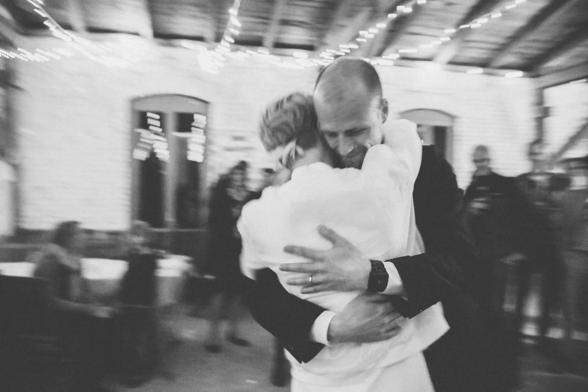 Black-and-white photograph of the wedding couple sharing an intimate moment during the celebration