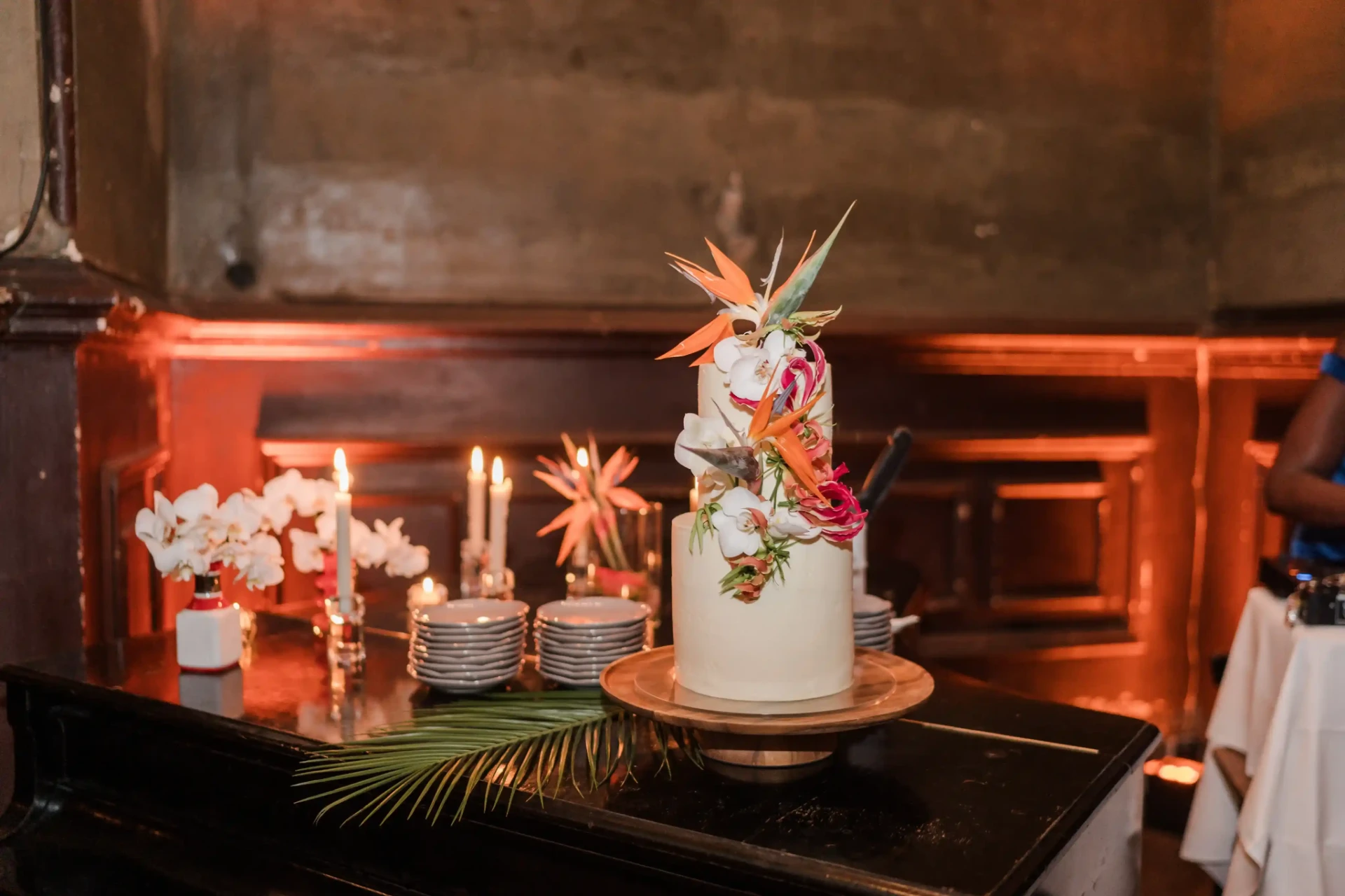 Wedding cake with colourful decoration on a table in front of wood panelling