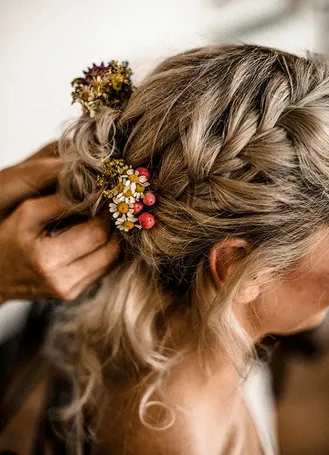 Bride having her hair styled during getting ready